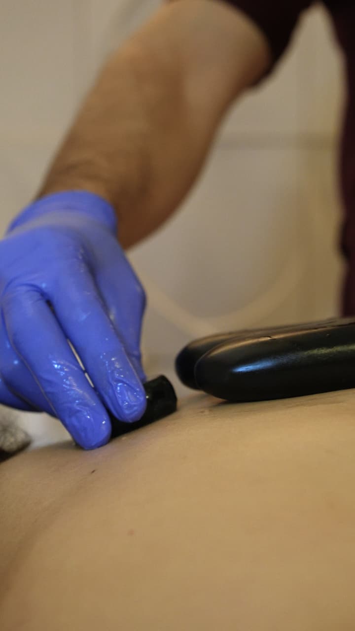 Massagem modeladora com pedras nas costas em clínica de estética em Goiânia
