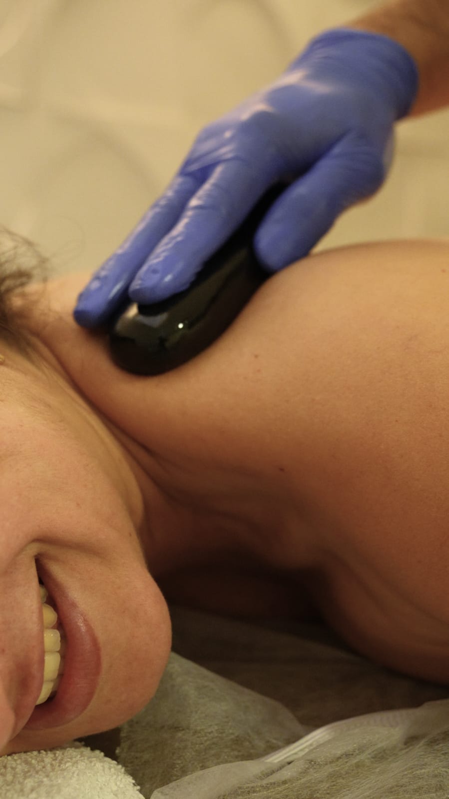 Massagem com pedras quentes no ombro em clínica de bem-estar no Marista, Goiânia